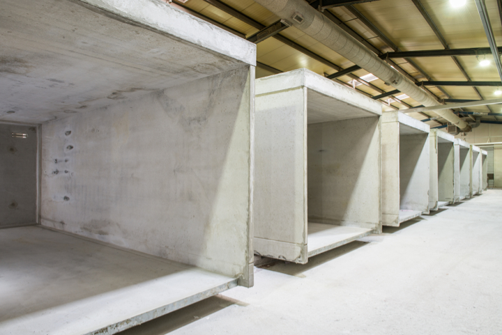 Reihe von Betonfertiggaragen in einem Innenbereich, zeigt die robuste Bauweise und Lagerkapazität.