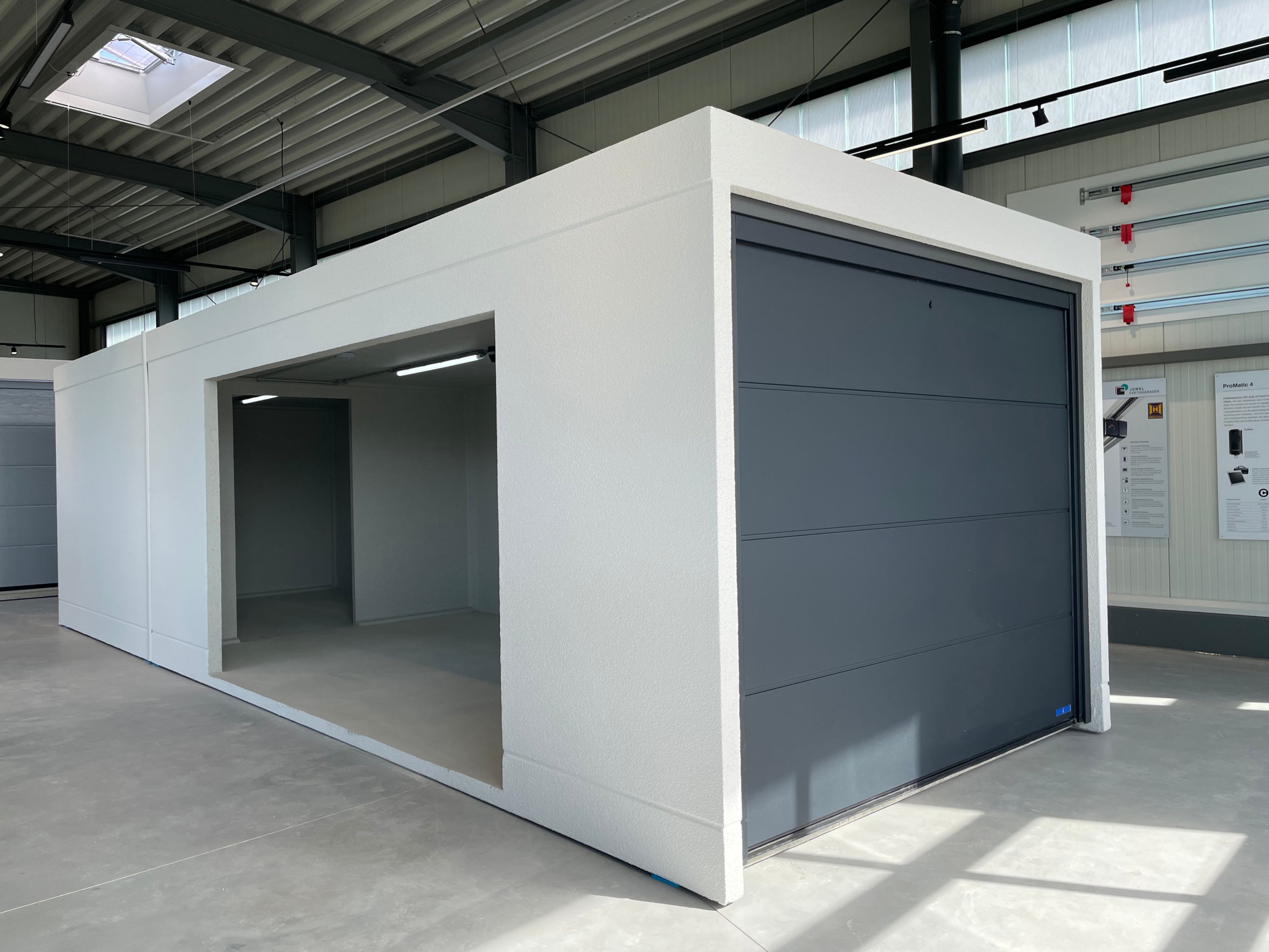 Garage Model Diamant mit Anbau & Aussparung in weiß mit grauen Tor im Showroom 